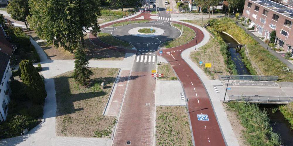 Luchtfoto van een rotonde in de heringerichte Bankastraat in Hengelo, met doorgetrokken fietspaden en woonwijk op de achtergrond.