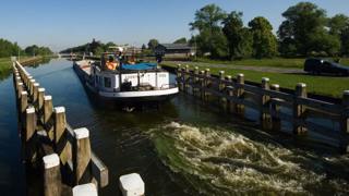  Een vrachtschip verlaat een sluis op een kanaal.