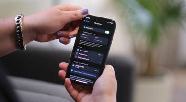 Een close-up van een persoon die een smartphone vasthoudt. Het scherm toont de instellingen van de Focus-modus (Niet storen), in het Nederlands.
