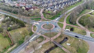 Luchtfoto van een rotonde met fietspaden en autowegen.