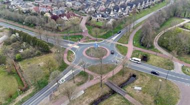 Luchtfoto van een rotonde met fietspaden en autowegen.