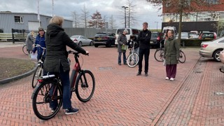 Stilstaande fietsers op strat in gesprek met een fietscoach
