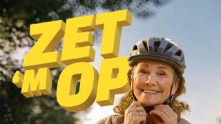 Een vrouw zet haar fietshelm op met de tekst 'ZET 'M OP' in beeld.