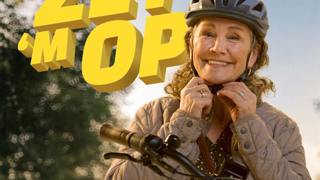 Een vrouw zet haar fietshelm op met de tekst 'ZET 'M OP' in beeld.