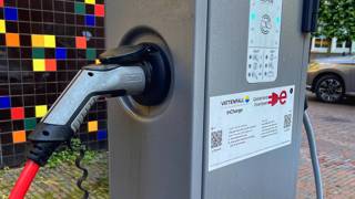 Laadpaal voor elektrische voertuigen met kleurrijke achtergrond.
