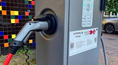 Laadpaal voor elektrische voertuigen met kleurrijke achtergrond.