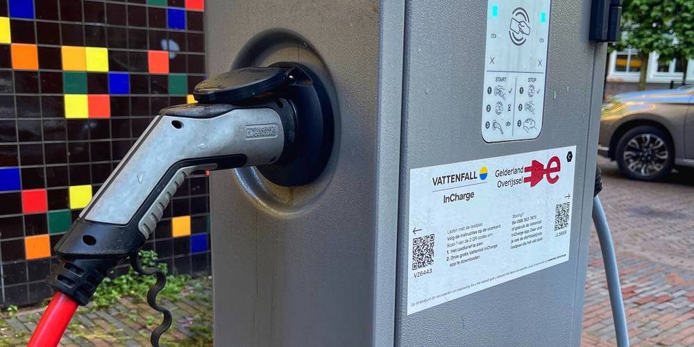 Laadpaal voor elektrische voertuigen met kleurrijke achtergrond.